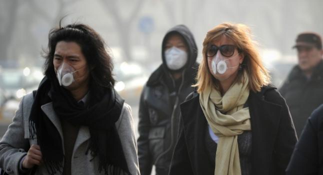 El cáncer al Pecho es el de mayor incidencia e las mujeres de América. Estudios revelan que influye el aire que se respira antes de su primera lactancia, En la fotografía, mujeres están llevando mascarillas mientras caminan por las calles de Beijing el 16 de enero de 2014. Científicos chinos identificaron 1.315 especies de microorganismos en el contaminado aire de la capital china. (Wang Zhao/AFP/Getty Images)