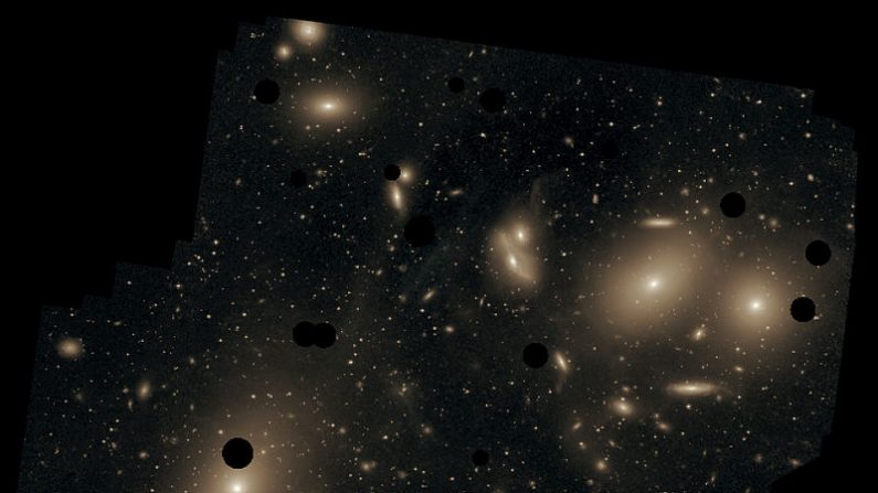 Imagen de gran tiempo de exposición de la región central del cúmulo de Virgo en la que se puede apreciar la luz difusa que existe entre las galaxias de éste, producida por estrellas intergalácticas. Los discos negros corresponden a estrellas que han sido eliminadas en la imagen. La galaxia más grande y brillante es la M87 abajo a la izquierda. (Chris Mihos (Case Western Reserve University)/ESO/Wikimedia Commons)