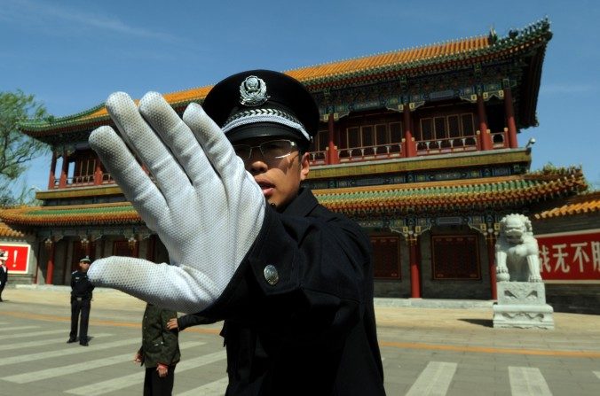 Un policía chino bloquea fotos tomadas afuera de Zhongnanhai, que sirve como la sede central del Partido Comunista de China, en Beijing el 11 de abril de 2012. (MARCA RALSTON / AFP / Getty Images)
