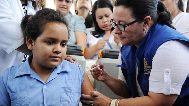 Una niña siendo vacunada contra el virus del papiloma humano (VPH) por los empleados del Ministerio de Salud en Tegucigalpa, el 17 de mayo de 2016. (ORLANDO SIERRA / AFP / Getty Images)