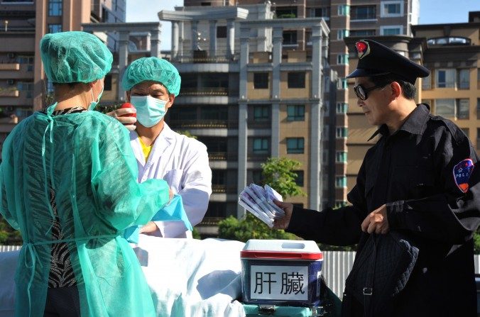 Practicantes de Falun Dafa dramatizan una  sustracción de órganos humanos para ser vendidos, durante una manifestación en Taipei el 20 de julio del 2014. (Mandy Cheng / AFP / Getty Images)