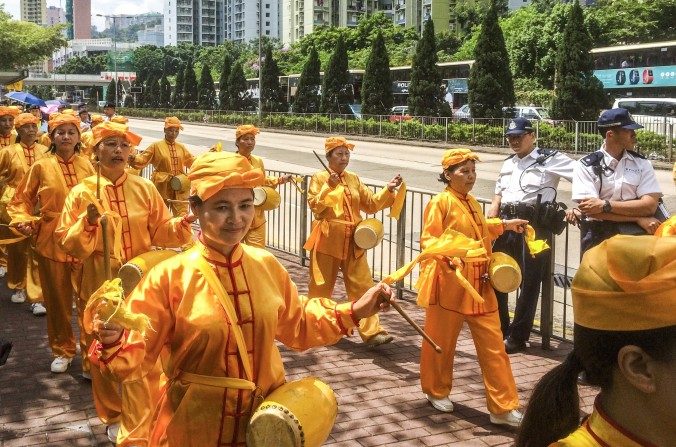 La Divine Land Marching Band, una banda de tambores a la cintura, marcha por las calles de Hong Kong para conmemorar los dieciséis años de persecución a Falun Dafa por parte de Partido Comunista Chino. (Phillip Evich/La Gran Época)