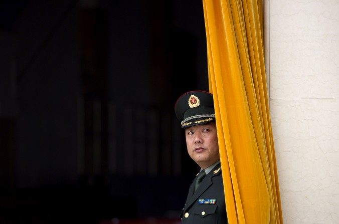 Un miembro del Ejército Popular de Liberación (EPL) espera detrás de una cortina en el Gran Palacio del Pueblo en Beijing el 25 de diciembre de 2011. (Ed Jones / AFP / Getty Images)