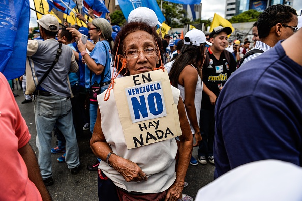 Un activista de la oposición de Venezuela lleva un cartel que decía "No hay nada en Venezuela" durante una manifestación pacífica contra la delincuencia y la escasez en el país, en Caracas, el 8 de agosto de 2015 (Photo credit should read FEDERICO PARRA / AFP / Getty Images)