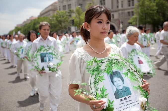 Practicantes de Falun Gong sostienen fotos de víctimas de la persecución en un desfile en Washington, el 18 de julio de 2011. (The Epoch Times)