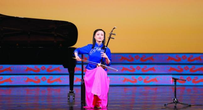 La virtuosa Xiaochun Qi toca el erhu, un instrumento tradicional chino, durante un espectáculo de Shen Yun Performing Arts. (La Gran Época)
