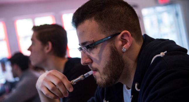 Hombre usando un cigarrillo electrónico en un café de Buenos Aires, mayo de 2014. (Andrew Burton/Getty Images)