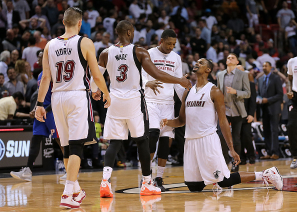 Chris Bosh #1 es ayudado encima por 3 Dwyane Wade de los Miami Heat (Foto por Mike Ehrmann/Getty Images)