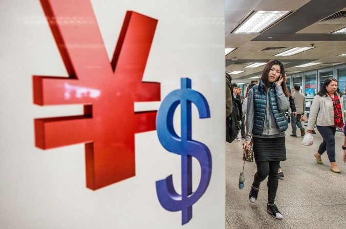 Símbolos del Yuan Chino (izquierda) y el dólar que se muestran en un almacén de Hong Kong. (Philippe López / AFP / Getty Images)