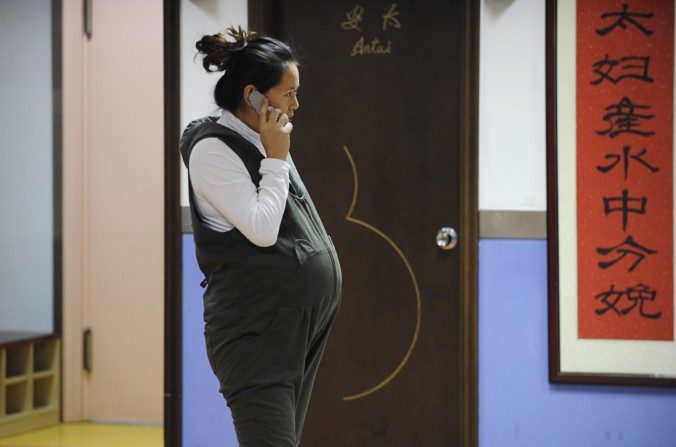 Una mujer embarazada habla por su teléfono celular en el Hospital Antai en Beijing el 28 de noviembre del 2012. Una escuela en la provincia de Henan multa a las maestras por quedar embarazadas en el primer semestre. (Wang Zhao / AFP / Getty Images)
