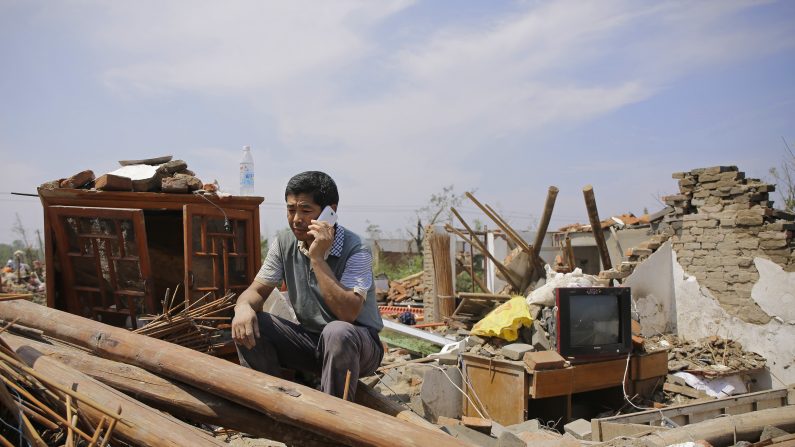 Una persona llama desde una casa colapsada en el pueblo Danping de la ciudad Yancheng, provincia de Jiangsu el 23 de junio de 2016. (Foto de Wang He/Getty Images)