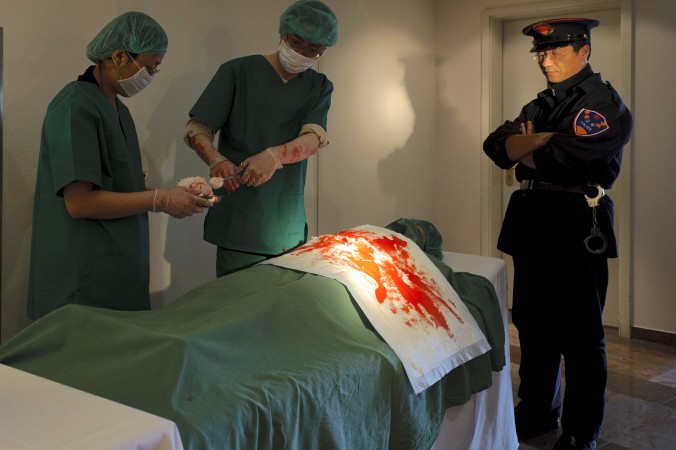 Practicantes de Falun Dafa reconstruyen la sustracción de órganos durante una reunión de la Sociedad Internacional para los Derechos Humanos en Cottbus, Alemania, el 14 de abril de 2012. (Robert Michael / AFP / Getty Images)