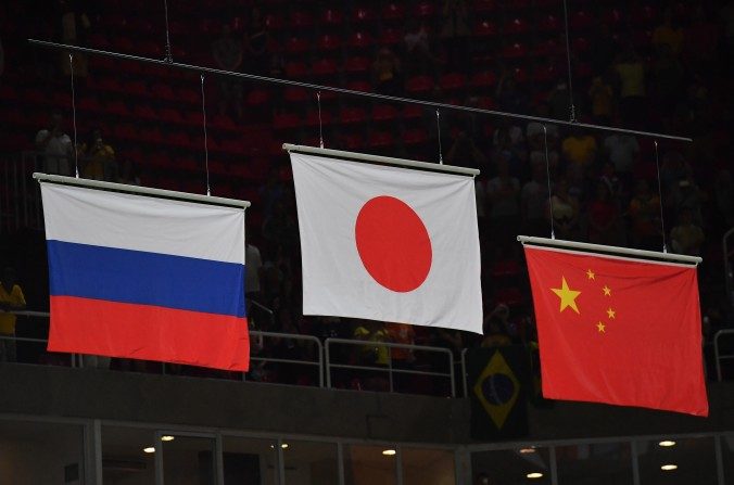 De izquierda a derecha: Las banderas de Rusia, Japón y china las cuales se muestran en el estadio Olímpico, después de la final masculina en gimnasia artística en los Juegos Olímpicos de Río, el 8 de agosto de 2016. (Ben STANSALL / AFP / GettyImages)