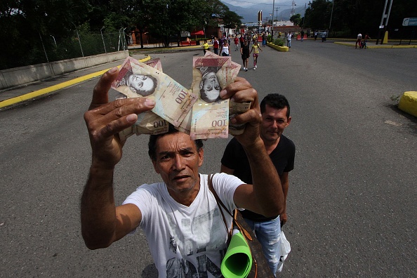 Un hombre muestra billetes de 100 bolívares en Venezuela. El domingo 11 de diciembre el presidente Nicolás Maduro ordenó que esos billetes no circularían más ya que denunció maniobras mafiosas detrás de su uso. ( GEORGE CASTELLANOS/AFP/Getty Images)