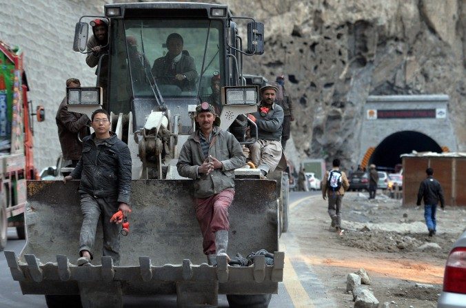 Trabajadores pakistaníes y chinos se sientan en una excavadora al dejar el túnel recién construido en el Valle Gojal de Pakistán, el 25 de septiembre de 2015. El proyecto es parte de la ambiciosa iniciativa de China, ‘Un cinturón, Un camino’. (Aamir Qureshi/AFP/Getty Images)