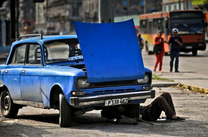 Un hombre repara su auto en la Habana, el 11 de enero de 2016. Un tercio de los autos que circulan en Cuba tienen fallas mecánicas y lo hacen sobre rutas destruidas. (YAMIL LAGE/AFP/Getty Images)