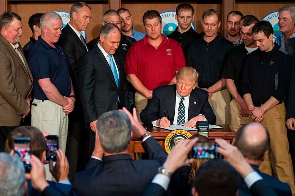 Donald Trump firmando la orden ejecutiva que revierte las regulaciones de la Era Obama, el 29 de marzo de 2917. Foto: JIM WATSON/AFP/Getty Images