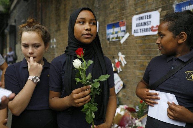 Niños de la escuela primaria Pakeman llegan a poner flores en homenaje a las víctimas del ataque del 19 de junio frente de la mezquita de Finsbury al norte de Londres. (TOLGA AKMEN/AFP/Getty Images)