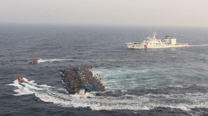 Una fotografía de archivo tomada el 21 de diciembre de 2017 desde un helicóptero surcoreano muestra a 12 barcos de pesca chinos atados con sogas para frustrar un intento de los barcos de la guardia costera de Corea del Sur de detener la pesca ilegal frente a la costa de Corea del Sur. (Crédito de PARK YOUNG-CHUL / AFP / Getty Images)