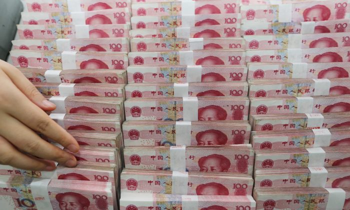 Un cajero cuenta billetes de yuan en un banco en Lianyungang, provincia de Jiangsu, China, 11 de agosto de, 2015. (STR/AFP/Getty Images)