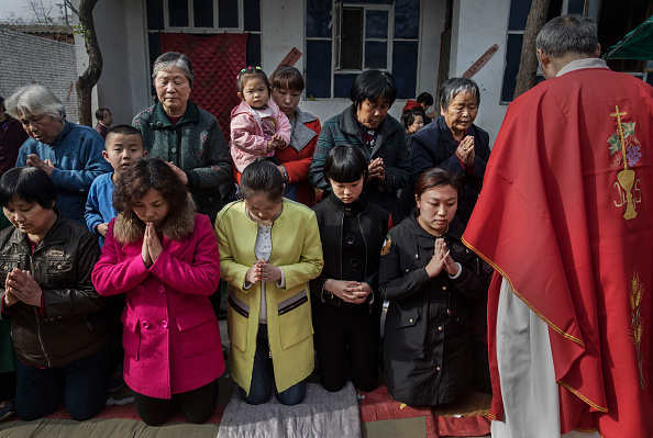 Chinos católicos esperan tomar la comunión en la misa de ramos, durante la semana santa, en una iglesia no oficial cerca de Shijiazhuang, provincia de Hebei, China, el 9 de abril de 2017. (Kevin Frayer/Getty Images)