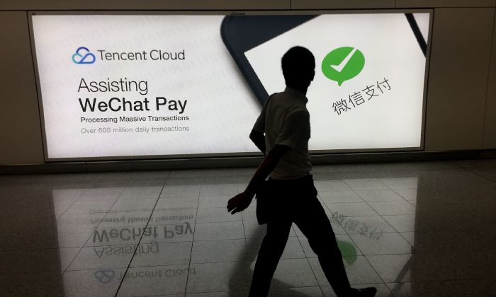 Un hombre pasa junto a un anuncio publicitario de la plataforma de red social WeChat en el aeropuerto internacional de Hong Kong, el 21 de agosto de 2017. (Richard A. Brooks/AFP/Getty Images)