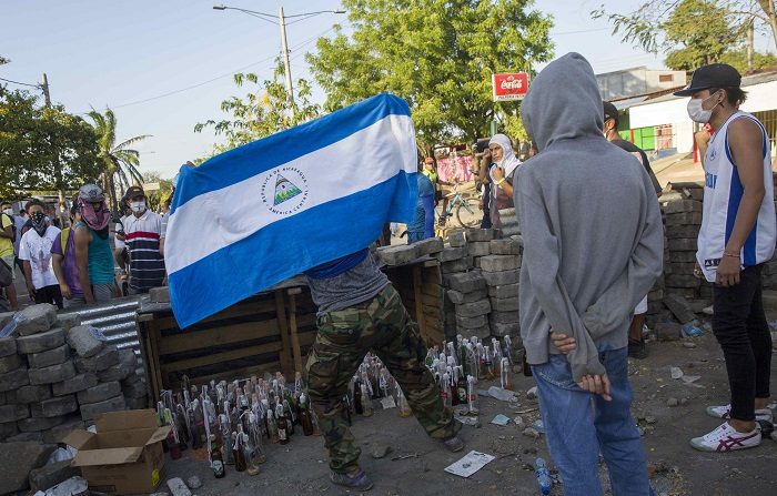 Varios jóvenes protestan hoy, domingo 22 de abril de 2018, durante el quinto día de manifestaciones en contra de una reforma a la seguridad social, en Managua (Nicaragua). Las protestas en Nicaragua han dejado unos 27 muertos, según estadísticas de ONG. , EFE/Jorge Torres  