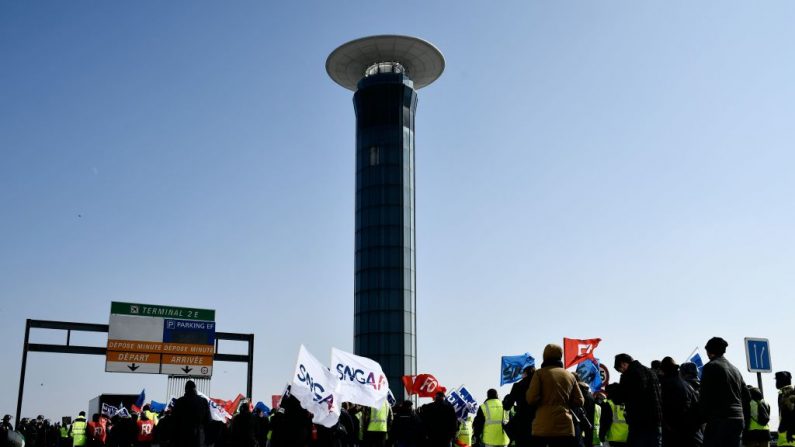 Los empleados de Air France en huelga caminan con banderas sindicales frente al aeropuerto Charles de Gaulle en Roissy. La mitad de vuelos de largo recorrido de Air France que salían de París fueron cancelados debido a una huelga de pilotos, tripulantes de cabina y personal de tierra. FOTOGRAFÍA AFP / Philippe LOPEZ. (El crédito de la foto debe leer PHILIPPE LOPEZ/AFP/Getty Images)