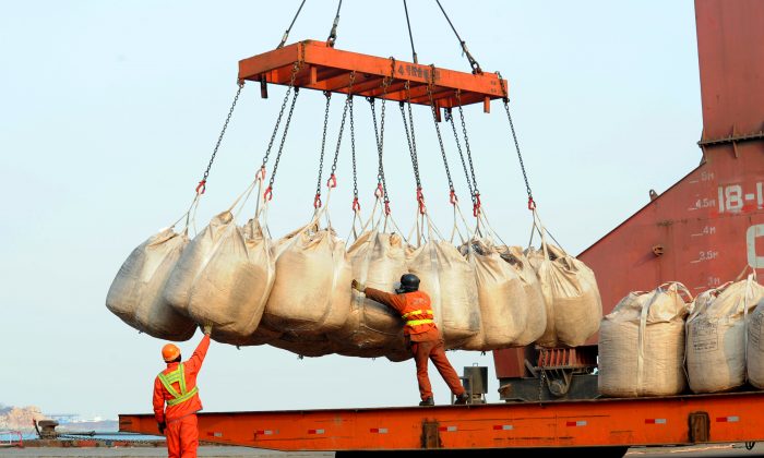 Trabajadores descargan mercancías de un barco en el puerto de Lianyungang, provincia de Jiangsu, en el este de China, el 12 de febrero de 2014.  (STR/AFP/Getty Images)