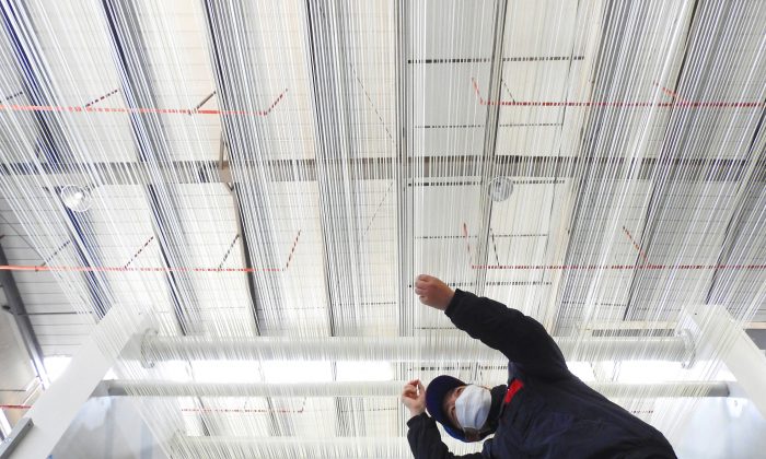 Foto tomada el 27 de febrero de 2018 que muestra a un empleado trabajando en una línea de producción de fibra de carbono T1000 en una fábrica en Lianyungang, en la provincia oriental de Jiangsu, China. (-/AFP/Getty Images) 