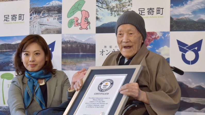 TOPSHOT - Masazo Nonaka de Japón (R), de 112 años de edad, recibe un certificado de Erika Ogawa (L), vicepresidenta de Guinness World Records Japan, en Ashoro, prefectura de Hokkaido, el 10 de abril de 2018.
Nonaka nació el 25 de julio de 1905. (JIJI PRESS/AFP/Getty Images)