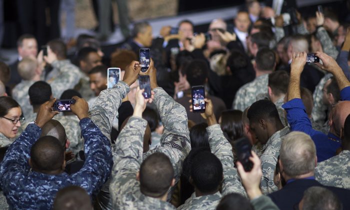 Miembros de las fuerzas armadas de Estados Unidos intentan grabar al presidente estadounidense Barack Obama con teléfonos inteligentes durante un discurso el 15 de diciembre de 2014 en Joint Base McGuire-Dix-Lakehurst, Nueva Jersey. (Mark Makela / Getty Images)