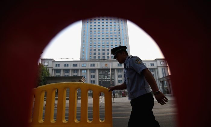 Un policía pasando cerca de los tribunales de la ciudad de Jinan, China, 22 de agosto de 2013. (Feng Li/Getty Images)
