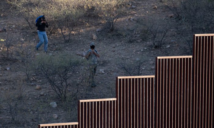 Dos hombres, posibles vigías del cártel, enmascaran sus rostros en el lado mexicano de la frontera cerca de Nogales, Arizona, el 23 de mayo de 2018. (Samira Bouaou / La Gran Época)