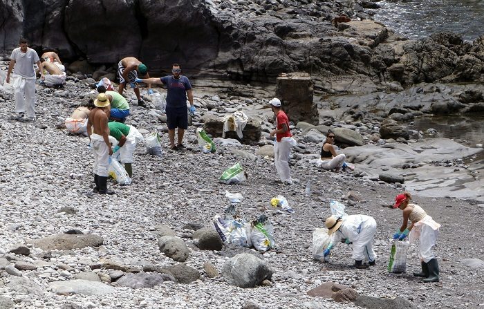GRA420. MOGÁN, (CANARIAS). 25/04/2015.- El vertido de fueloil del Oleg Naydenov, se extiende por la costa suroeste de Gran Canaria. En la imagen grupos de voluntarios en tareas de limpieza, Playa de La Cantera (Mogan). EFE/quique curbelo