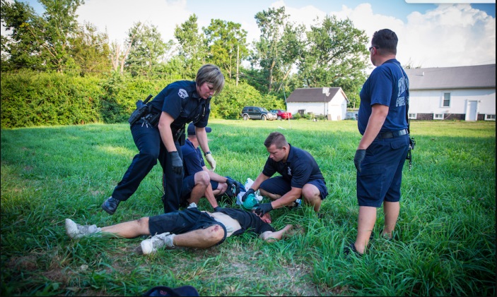 Policía local y paramédicos administran Narcan, un bloqueador de opioides, para revivir a un hombre en estado de sobredosis en el vecindario Drexel de Dayton, Ohio, el 3 de agosto de 2017. (Benjamin Chasteen/The Epoch Times)