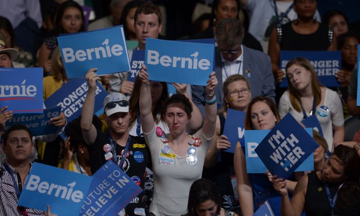 Simpatizantes del senador Bernie Sanders y Hillary Clinton con carteles en el día 1 de la Convención Nacional en el Centro Wells Fargo en Filadelfia el 25 de julio de 2016. (BRENDAN SMIALOWSKI/AFP/Getty Images)