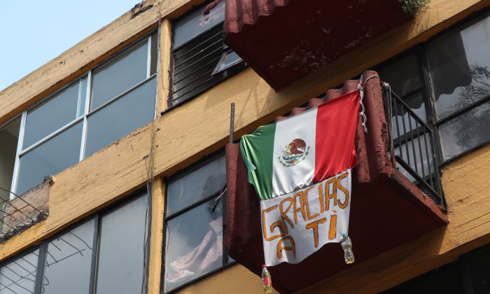 Una bandera mexicana con un cartel que dice “gracias a ti” en un edificio de Multifamiliar Tlalpan, una urbanización al sur de la Ciudad de México que sufrió muchos daños durante el terremoto de México de 2017, el 19 de septiembre de 2018. (Tim MacFarlan/Especial para La Gran Época)