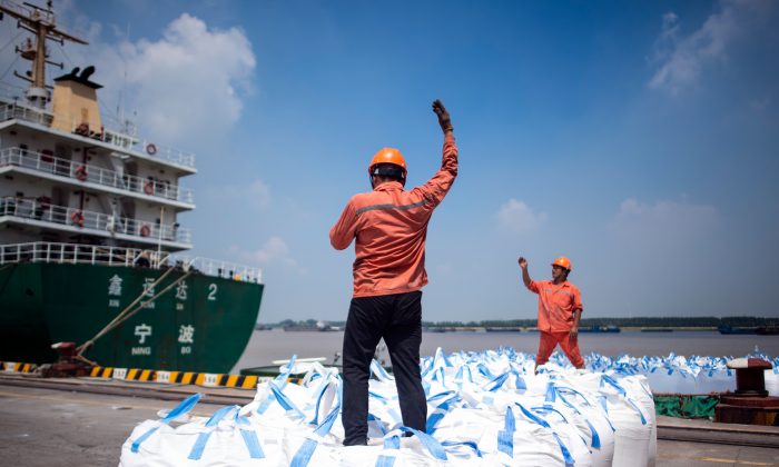Trabajadores portuarios descargan bolsas de productos químicos en un puerto de Zhangjiagang, en la provincia de Jiangsu, China, el 7 de agosto de 2018. (JOHANNES EISELE/AFP/Getty Images)