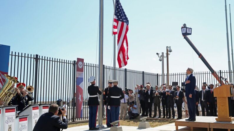 El entonces secretario de Estado John Kerry (Der.) de pie mientras los marines izan la bandera estadounidense en la Embajada de EE. UU. el 14 de agosto de 2015 en La Habana, Cuba. Se cree que diplomáticos estadounidenses en Cuba han sido atacados en sus casas con armas sónicas desde fines de 2016. (Chip Somodevilla/Getty Images)