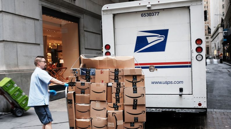 Un trabajador del Correo de los Estados Unidos entrega cajas Amazon fuera de la Bolsa de Valores de Nueva York (NYSE) el 11 de octubre de 2018 en la ciudad de Nueva York. (Foto de Spencer Platt/Getty Images)