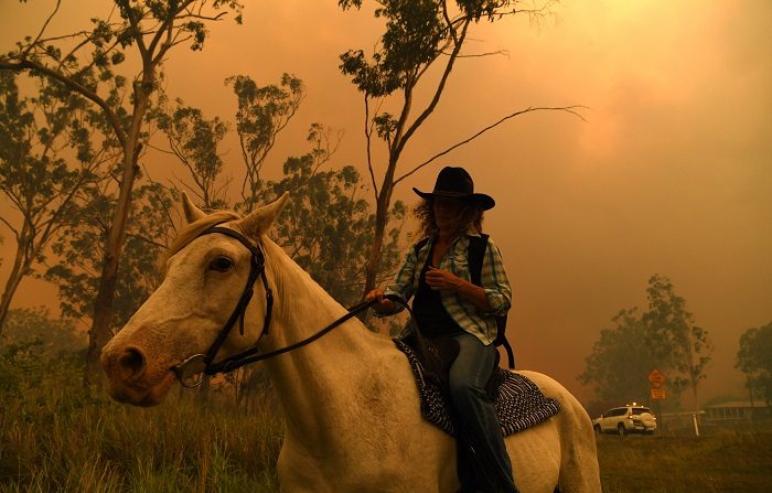 La australiana Rhonda Anderson evacúa sus tierras junto a su caballo durante un incendio cerca de Monte Larcom en Queensland (Australia) hoy, 28 de noviembre de 2018. Australia se ve hoy afectada por unas condiciones meteorológicas sin precedentes que han causado inundaciones en varios suburbios de Sídney, en el este del país, y decenas de incendios en el estado de Queenland, en el noreste. EFE/Dan Peled PROHIBIDO SU USO EN AUSTRALIA Y NUEVA ZELANDA