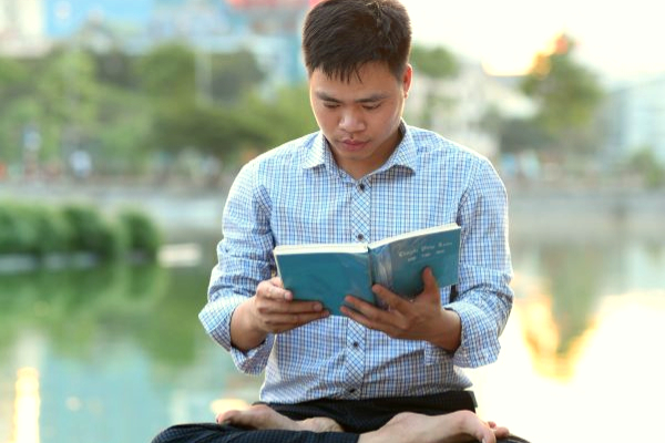 joven en doble loto leyendo Zhuan Falun