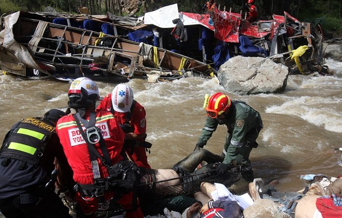 Imagen de contexto de rescatadores que recogen cadáveres de un autobús que se estrelló mientras conducía por la carretera al norte de Lima. AFP PHOTO/STR (El crédito de la foto debe leer STR/AFP/Getty Images)