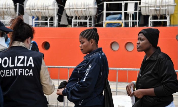 Una mujer nigeriana y otros migrantes desembarcan del MV Aquarius a su llegada al puerto siciliano de Messina, el 14 de mayo de 2018. (Louisa Gouliamaki/AFP/Getty Images)