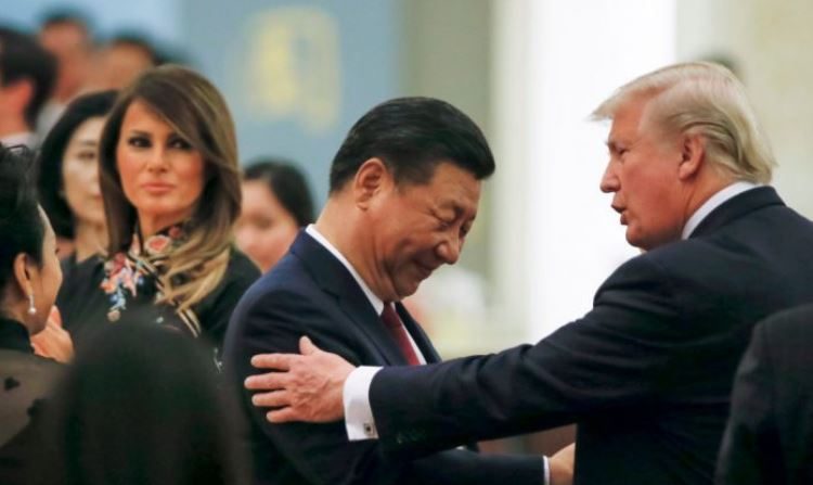 El presidente de los Estados Unidos, Donald Trump, habla con el mandatario de China, Xi Jinping, mientras la Primera Dama de los Estados Unidos, Melania Trump observa, durante una cena de estado en el Gran Palacio del Pueblo en Beijing el 9 de noviembre de 2017. (THOMAS PETER/AFP/Getty Images)