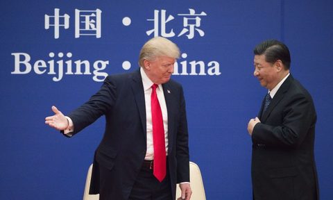 El presidente de Estados Unidos, Donald Trump (izq.), hace un gesto al mandatario de China, Xi Jinping, durante un evento de líderes empresariales en el Gran Salón del Pueblo de Beijing, el 9 de noviembre de 2017.(NICOLAS ASFOURI/AFP/Getty Images)
