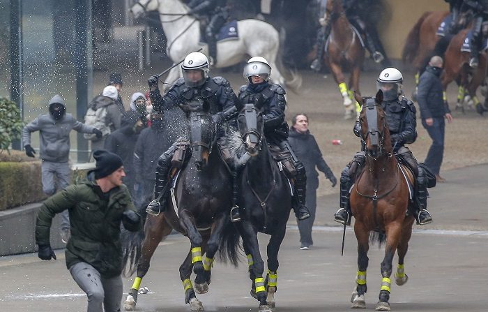 Policías a caballo persiguen a manifestantes de asociaciones flamencas de derecha durante la manifestación "Marcha contra Marrakech" cerca de la sede de las instituciones europeas en Bruselas, Bélgica, el 16 de diciembre de 2018. (Protestas, Bélgica, Bruselas) EFE/EPA/JULIEN WARNAND