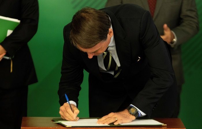 El presidente de Brasil, Jair Bolsonaro, firmó hoy el decreto que facilita la posesión de armas de fuego en el país, una de sus principales promesas durante la campaña electoral. EFE/Joédson Alves