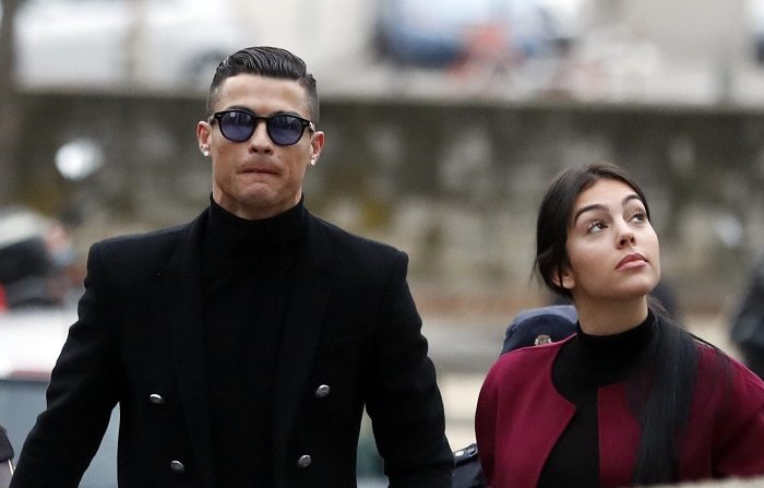 El exjugador del Real Madrid Cristiano Ronaldo, junto a su pareja Georgina Rodríguez, a su llegada este martes a la Audiencia Provincial de Madrid, donde se celebra el juicio en el que será condenado a dos años de prisión y al pago 18,8 millones de euros en virtud del pacto al que llegó con la Fiscalía y con Hacienda, por el que reconoció haber cometido cuatro delitos fiscales entre 2011 y 2014. EFE/Javier Lizón